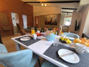 a table with food on it in a living room at Ferienhaus "WaldLust" - Waldrandlage - Haustierfreundlich in Gerolstein +21 photos