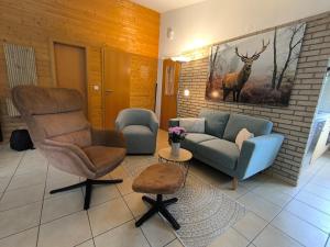 a living room with a couch and a chair at Ferienhaus "WaldLust" - Waldrandlage - Haustierfreundlich in Gerolstein