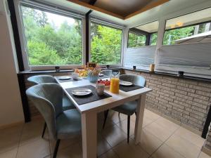 a kitchen with a table and chairs and windows at Ferienhaus "WaldLust" - Waldrandlage - Haustierfreundlich in Gerolstein +21 photos