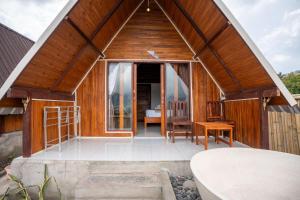 a wooden house with a large glass door at Tirta Rahayu Camp in Kubupenlokan