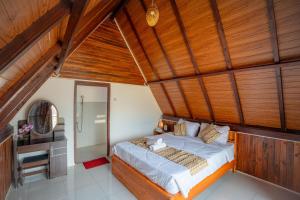 a bedroom with a bed and a wooden ceiling at Tirta Rahayu Camp in Kubupenlokan +11 photos