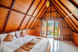 a bedroom with a bed in a room with wooden walls at Tirta Rahayu Camp in Kubupenlokan