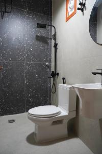 a bathroom with a toilet and a shower and a sink at Misfah Allure in Misfāh