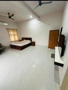 Cette chambre comprend un lit et une télévision. dans l'établissement Ekant The Luxury Farm, à Jaipur