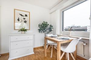 Un comedor con una mesa de madera y sillas blancas. en SOHO3A !Gratis Parken, Free Parking!, en Kreuzlingen