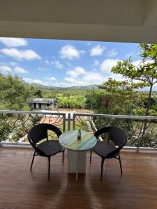 Una mesa y sillas en un balcón con vista. en Estillo -River touch, Mountain view, en Mundhwa