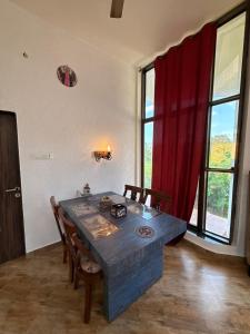 Un comedor con una mesa azul y una cortina roja. en Estillo -River touch, Mountain view, en Mundhwa