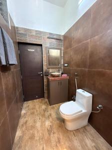 Un baño con inodoro y una pared marrón. en Estillo -River touch, Mountain view, en Mundhwa 13 fotos más