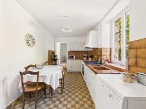a kitchen with a table and chairs and a sink at Plein centre - Maison pour 4 avec jardin in Montignac