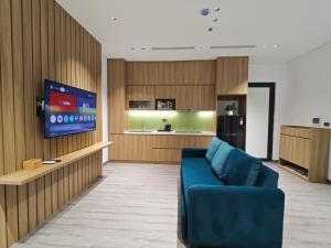 河内Minerva Aparthotel Hanoi的带蓝色沙发的客厅和厨房
