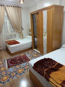 a bedroom with two beds and a window with rugs at الزقازيق فلل الجامعه برج رويال بلازا in Kafr az Zand
