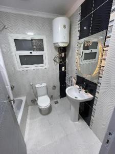 a white bathroom with a toilet and a sink at الزقازيق فلل الجامعه برج رويال بلازا in Kafr az Zand