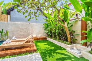 a small garden with a bench and grass at Esmeralda1 BR Shared Pool ZN284 in Pererenan