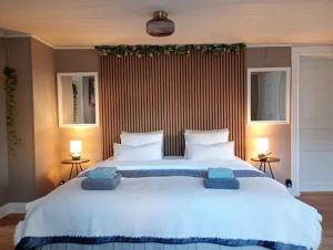ein großes weißes Bett in einem Schlafzimmer mit zwei Lampen in der Unterkunft B&B Rutgården in Norberg