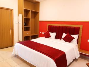 a bedroom with a large bed with a red headboard at tan90 Comfort Stays in Tiruchchirāppalli +6 photos