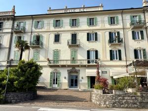 - un grand bâtiment blanc avec des fenêtres et des balcons dans l'établissement Cadenabbia Lake Front View Suite, à Griante Cadenabbia