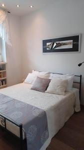 a bedroom with a bed with white sheets and pillows at A-Mare in Viareggio