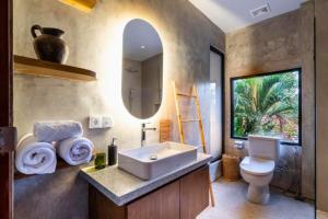 a bathroom with a sink and a toilet and a mirror at Esmeralda1 BR Shared Pool ZN284 in Pererenan +28 photos