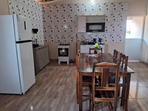 a kitchen with a table and chairs and a refrigerator at Casa vila costeira Guriú piso superior in Guriú +8 photos