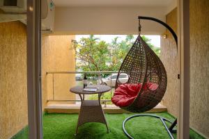 a room with a hammock and a table and a window at Nayaab by Leo Homes - 2BHK Flat near Anjuna Beach in Anjuna