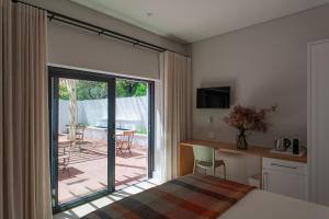 une chambre avec un lit et une porte coulissante en verre dans l'établissement Minserie Collection, à Stellenbosch