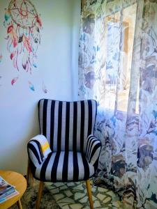 a striped chair in a room with a window at O Curro de Arou 1 in Arou +1 photo