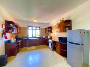a kitchen with wooden cabinets and a white refrigerator at Shabiki Sea View Apartments in Mombasa