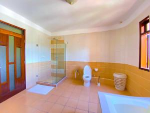 a bathroom with a toilet and a glass shower at Shabiki Sea View Apartments in Mombasa +5 photos
