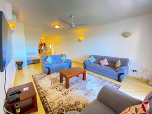 a living room with two blue couches and a table at Shabiki Sea View Apartments in Mombasa