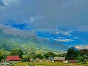 a village with houses and mountains in the background at Eco green Homestay in Sa Pa