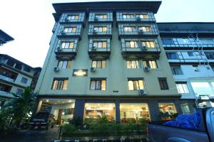 un edificio alto con muchas ventanas en una calle en DEWALING by Laughing Lama Hotels, en Phuntsholing