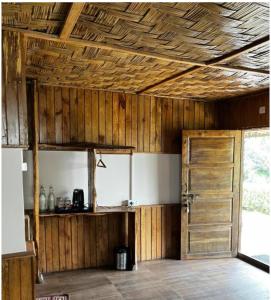 a kitchen with a wooden ceiling and a door at The Nettle and Fern Farmstay in Pelling