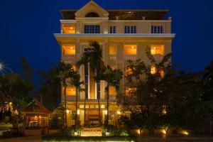 a large white building with lights at night at Grand Bayon Siem Reap Hotel in Siem Reap