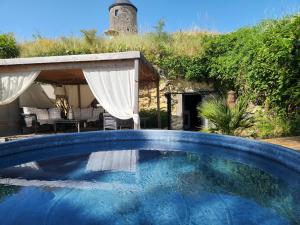 une grande piscine devant une maison dans l'établissement Le Tunnel du Moulin, à Noyers-sur-Cher