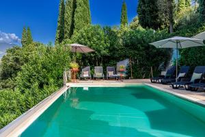 a swimming pool with chairs and umbrellas at Panoramic Lake View Apartments with Pool & Breakfast in Torri del Benaco