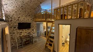 a room with a loft with a staircase and a tv at Sadarmis Houses in Leonidio