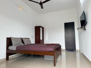 a bed in a room with a ceiling fan at Kavitha Stay Inn in Nāmakkal