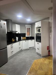 a large kitchen with white cabinets and appliances at Apartament z widokiem na morze Cabo Roig in Orihuela Costa