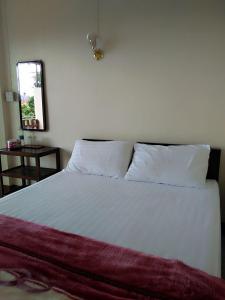 a bed with white sheets and pillows in a bedroom at เอวาเฮ้าส์ ภูชี้ฟ้า avahouse phuchifa in Ban Seng Choi