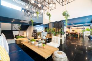 a store with tables and chairs and potted plants at MORE Patong Hotel in Patong Beach
