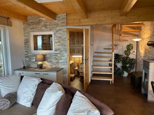 a living room with a couch and a staircase at Panoramahütte Hochrindl in Hochrindl