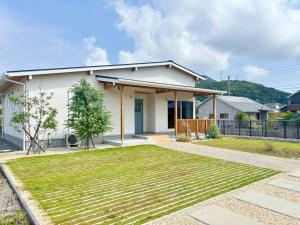 ein weißes Haus mit einem Rasen davor in der Unterkunft Nagasaki - House - Vacation STAY 19938 in Nagasaki