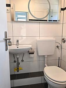 クックスハーフェンにあるLütte Koje 207 - Ferienwohnung 1 Zimmer Alteliebeのトイレ、洗面台、鏡のあるバスルーム +11枚の写真