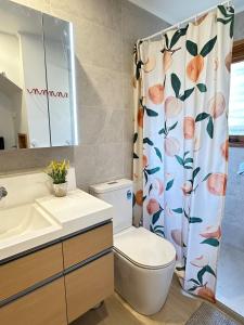 a bathroom with a toilet and a shower curtain at Camellia Romance Retreat near Doncaster Westfield M3 in Doncaster +11 photos