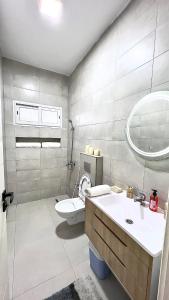 a bathroom with a toilet and a sink and a mirror at Mediterranean house in Djerba Midoun in Taguermess