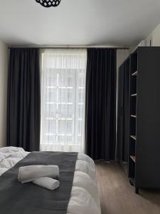 Un dormitorio con una cama y una ventana grande en Rihlaa aprt c 1105, en Itʼkhvisi