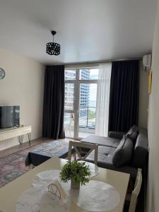 una sala de estar con un sofá y una mesa en Rihlaa aprt c 1105, en Itʼkhvisi