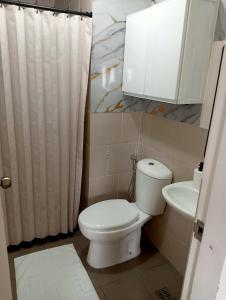 a bathroom with a toilet and a sink at Holland Park in Biñan