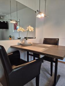 a dining room table with black chairs and a table with flowers on it at Casa Breiten in Breiten