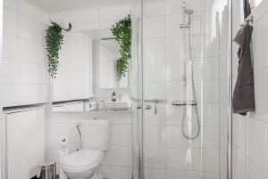 Un baño blanco con inodoro y ducha. en Cute and Cozy Guesthouse near Water, en Tyresö 11 fotos más